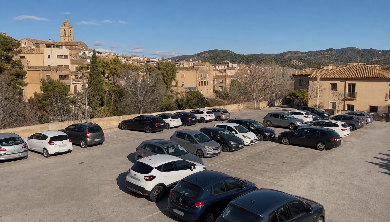 Aparcamiento de superficie en el borde de la ciudad de Granada con parada de bus cercana.
